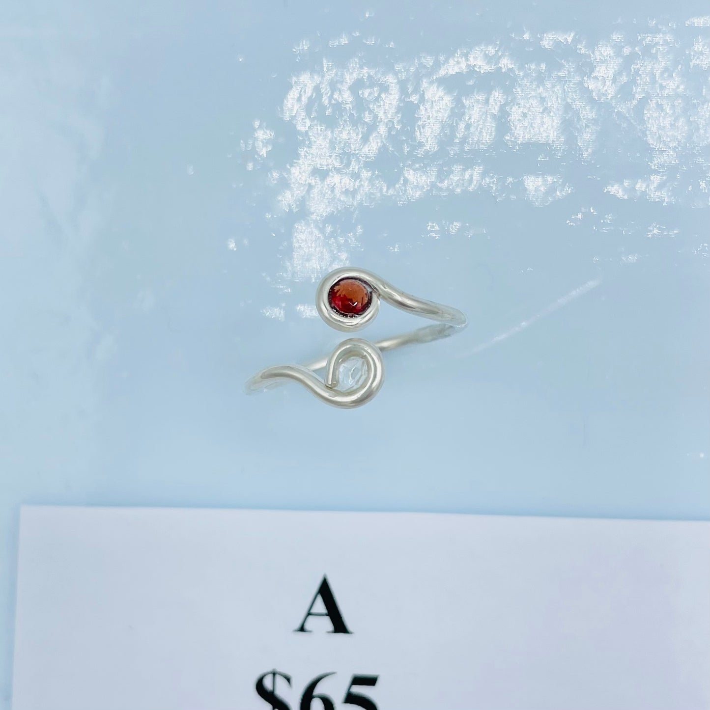 Argentium silver with A faceted Garnet on one side