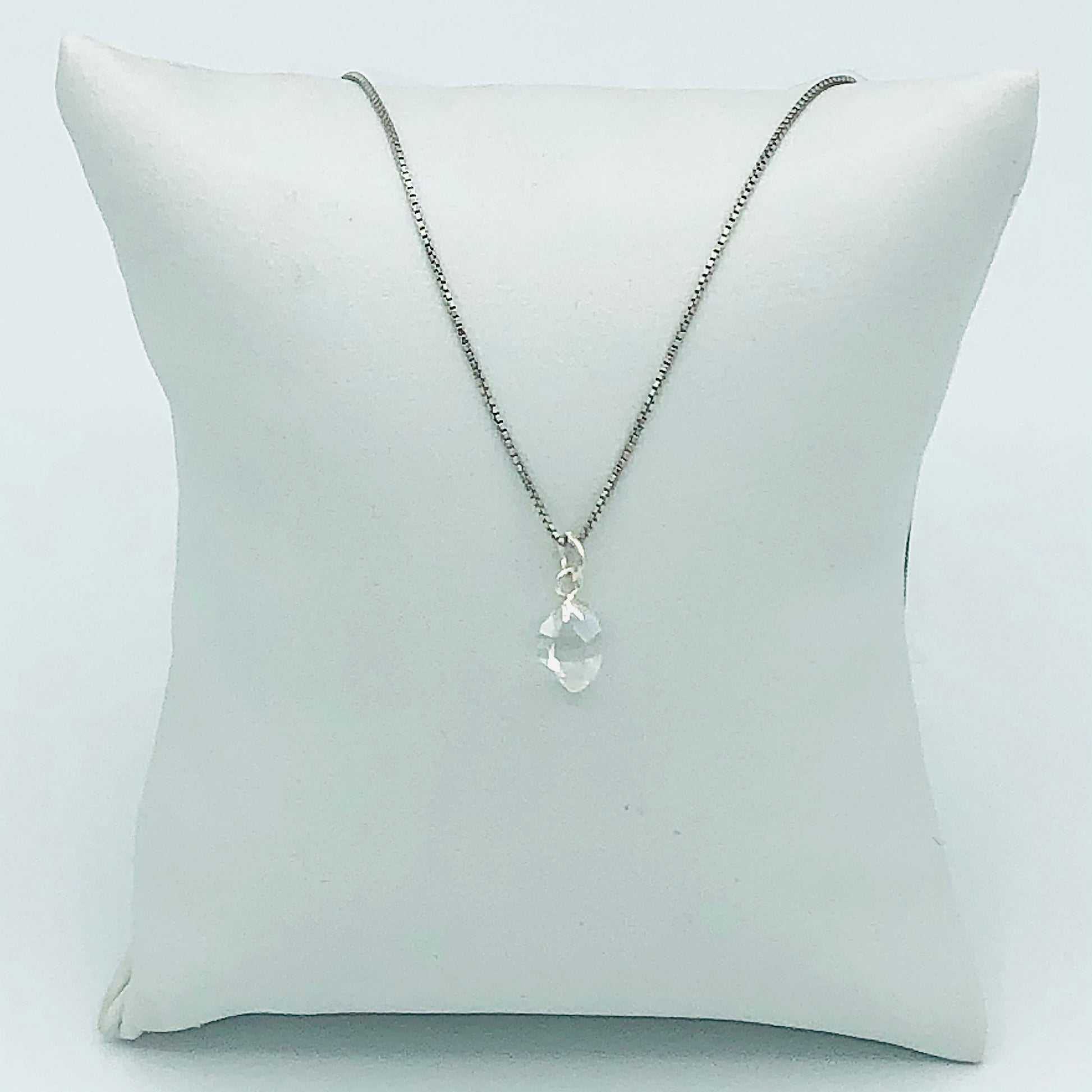 Herkimer Diamond Rhodium Plated Sterling Silver Box Chain on a jewelry pillow. (The Jewelry pillow is intended to be a prop and is not included in the purchase of the necklace. )