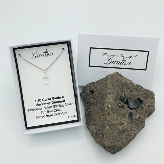 Herkimer Diamond Rhodium Plated Sterling Silver Box Chain in Lumina Package next to Herkimer Diamond Specimen (The Herkimer Diamond Specimen is intended to be a prop and is not included in the purchase of the necklace).