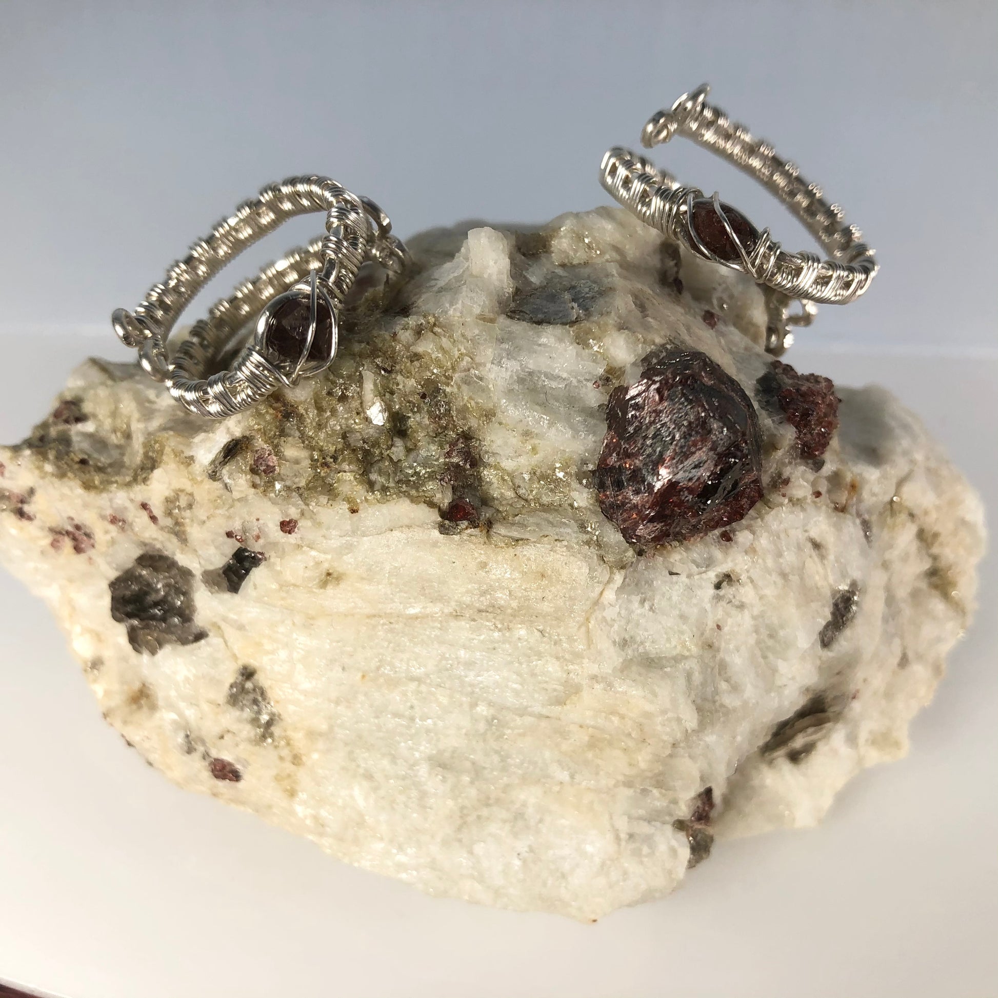 Specimen with Garnets showcasing two Argentium Silver Wrap Garnet Rings (1 ring per order. Specimen is not included)